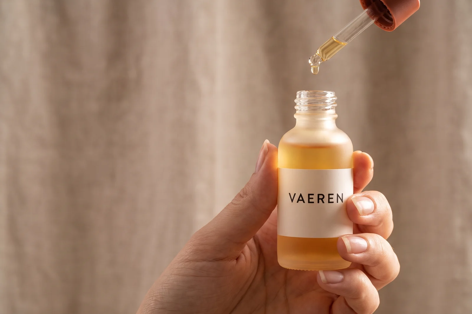 Hand met een flesje VAEREN-serum