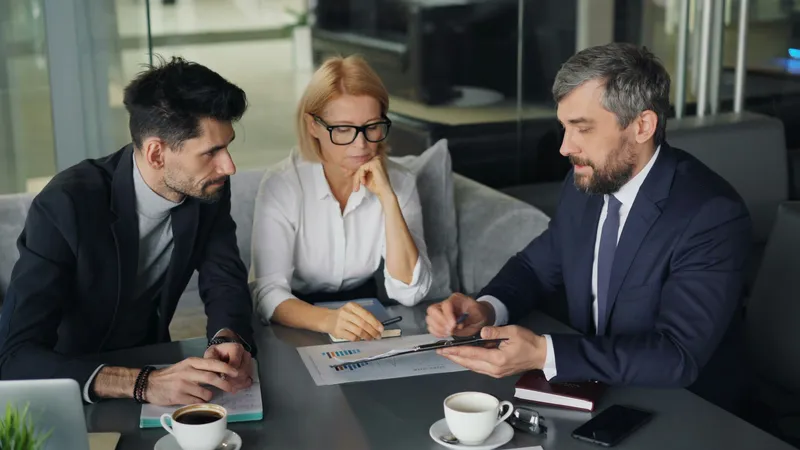 Drie mensen in overleg aan een tafel